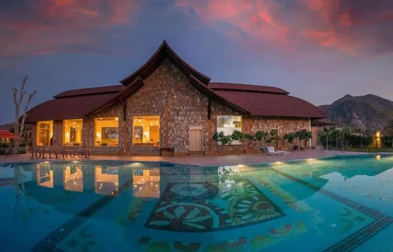 The poolside pavilion at sunset, reflected in a mosaic-tiled pool